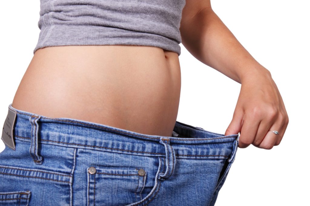 person holding baggy pants after weight loss